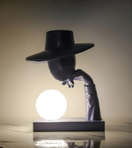 Modern sculptural table lamp with human figure design and glowing orb light for luxury interior décor