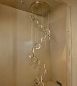 Modern ceiling light fixture with hanging rings in a neutral setting