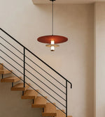 Modern pendant light above minimalist wooden staircase with black metal railing