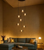 Modern living room with pendant chandelier, green sectional sofa, and gold accent decor