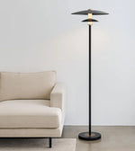Modern floor lamp next to a beige sofa in a minimalistic room