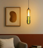 Modern pendant light with ribbed glass above a cozy armchair, wall art, and books in a stylish living room.