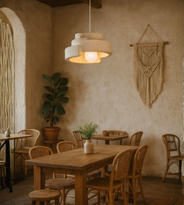 Rustic beige foam pendant with stacked clay-like design in a warm earthy dining space