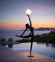Modern ballet sculpture floor lamp with dancer figure holding illuminated globe in minimalist interior