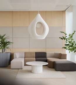 White sculptural foam pendant light hanging above a modern living room.