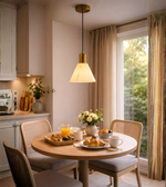 Modern marble effect cone pendant light with brass finish hanging above dining table in contemporary interior