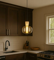 Modern glass pendant light fixture hanging in a contemporary kitchen interior