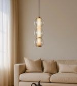 Modern glass pendant light above beige sofa in minimalist living room decor