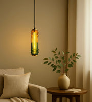 Modern glass pendant light above beige sofa and side table with plant in cozy living room