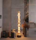 Modern marble effect stacked floor lamp glowing in cozy living room