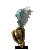 Statue of a human with gold body and teal wings on a white background