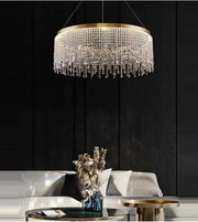 Modern crystal chandelier over elegant living room with gold tables and plush sofa