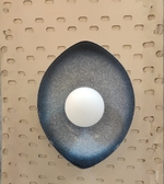 Decorative wall light fixture on a pegboard background