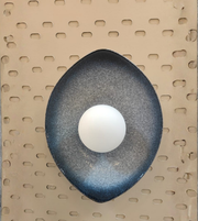 Decorative wall light fixture on a pegboard background