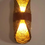 Wicker wall sconce with a warm glow on a plain background