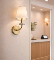 modern brass wall sconce with fabric shade in hallway