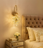 Petal Luxe gold and glass flower wall light illuminating a luxury bedroom.