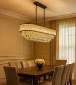 Regalia gold crystal chandelier with tiered design lighting a sophisticated dining area.