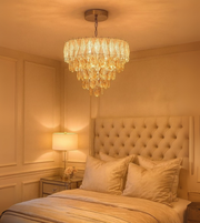 Aurora Cascade gold crystal chandelier illuminating a luxury bedroom interior.