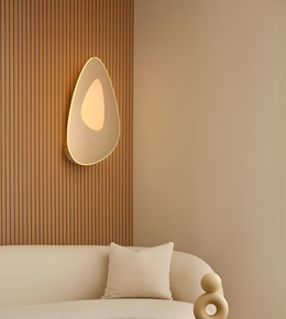 Modern organic-shaped wall sconce with warm diffused LED lighting in a minimal living room