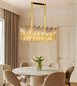 Leaf etched glass dining chandelier with warm lighting above a marble dining table in a luxury interior