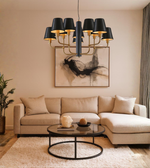 Black shade chandelier with brass arms illuminating a luxury living room interior with warm ambient lighting