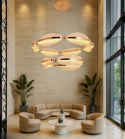 Orbital Grand Chandelier glowing above a modern lounge with beige interiors.