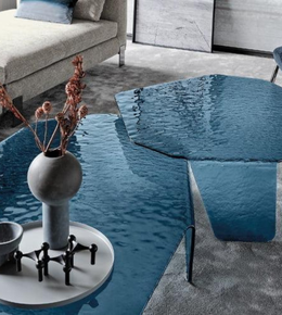 Pair of sculpted glass coffee tables with sleek, modern design featuring clear glass surfaces and curved bases.