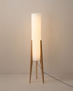 Minimalist wooden floor lamp with cylindrical white fabric shade on tripod base