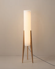 Minimalist wooden floor lamp with cylindrical white fabric shade on tripod base