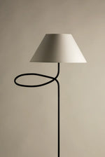 Minimalist designer floor lamp with fabric shade on neutral background