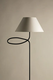 Minimalist designer floor lamp with fabric shade on neutral background