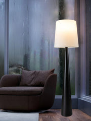 Elegant floor lamp with white shade near window creating warm ambient lighting