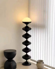 Black designer floor lamp with warm ambient glow near window