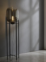 Minimalist floor lamp with smoked glass shade in modern interior
