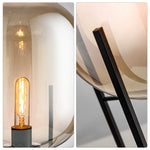 Close-up of exposed filament bulb inside amber glass lamp
