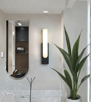 Designer wall sconce beside mirror with marble diffuser