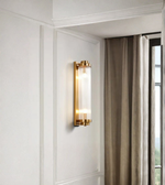 Wall-mounted lamp with gold finish on a white wall