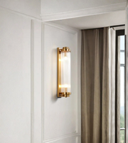 Wall-mounted lamp with gold finish on a white wall