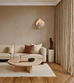 Modern living room with beige sofa, wooden coffee table, and wall-mounted light fixture.