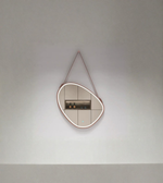 Modern wall mirror with a unique frame design on a plain wall.