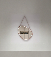 Modern wall mirror with a unique frame design on a plain wall.