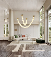 Modern living room with a chandelier, sofa, and large windows.