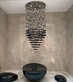 Modern shower head with black stones in a tiled bathroom