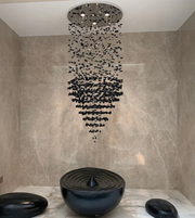 Modern shower head with black stones in a tiled bathroom
