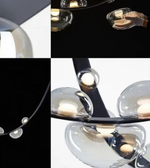 Close-up of a modern chandelier with glass shades on a black background
