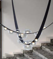 Modern chandelier with glass bubbles hanging over a staircase