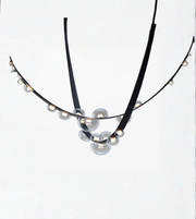 Necklace with black cord and clear beads on a white background