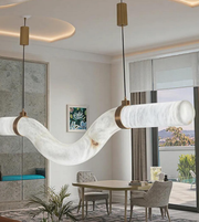 Modern dining room with marble pendant lights, table, chairs, and decor.