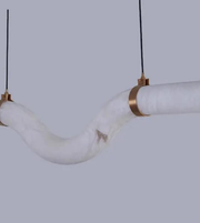 Curved white marble pendant light with gold accents on a plain background